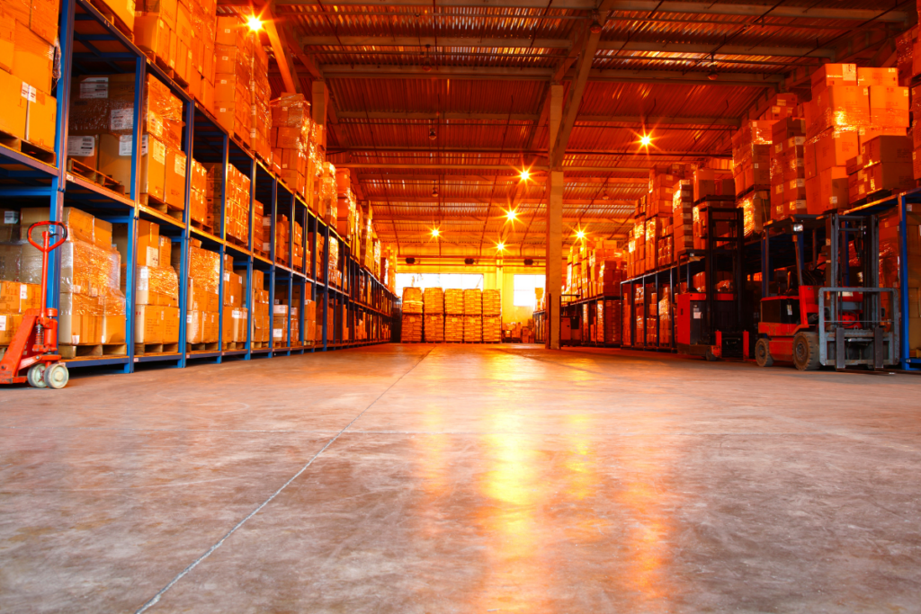 “Sunlight streaming through warehouse windows, casting an orange hue, representing Professional Risk & Asset Management’s expertise in warehouse risk management, security, and operational control.”