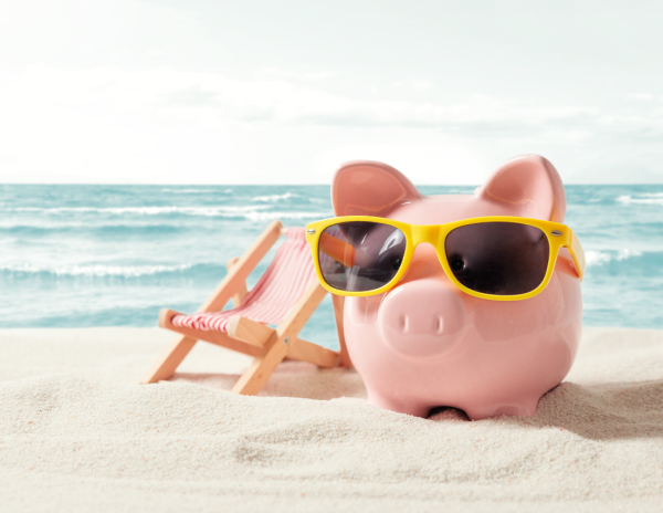 “Piggy bank wearing sunglasses on the beach next to a lounge chair, representing creative financial planning and fun at Professional Group Budget Day 2024.”