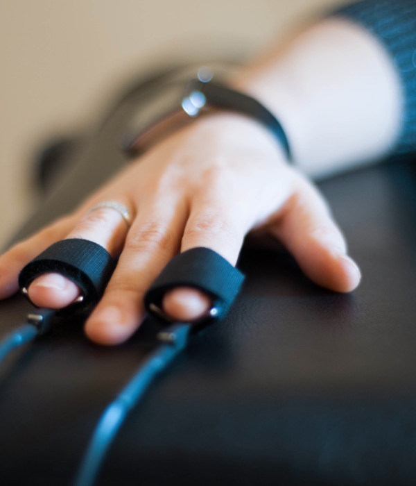 “Polygraph machine bands attached to fingers, representing professional polygraph services, credibility verification, and forensic assessment solutions.”
