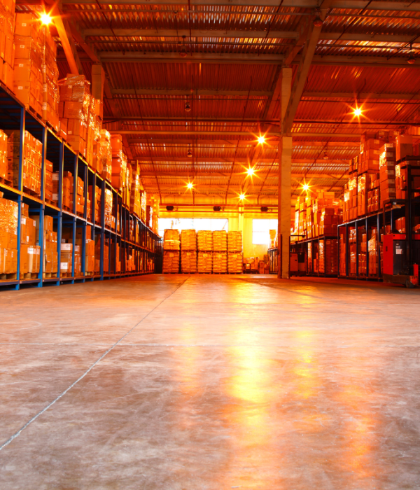 “Sunlight streaming through warehouse windows, casting an orange hue, representing Professional Risk & Asset Management’s expertise in warehouse risk management, security, and operational control.”